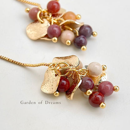 Gold necklace with colorful beads on a light background
