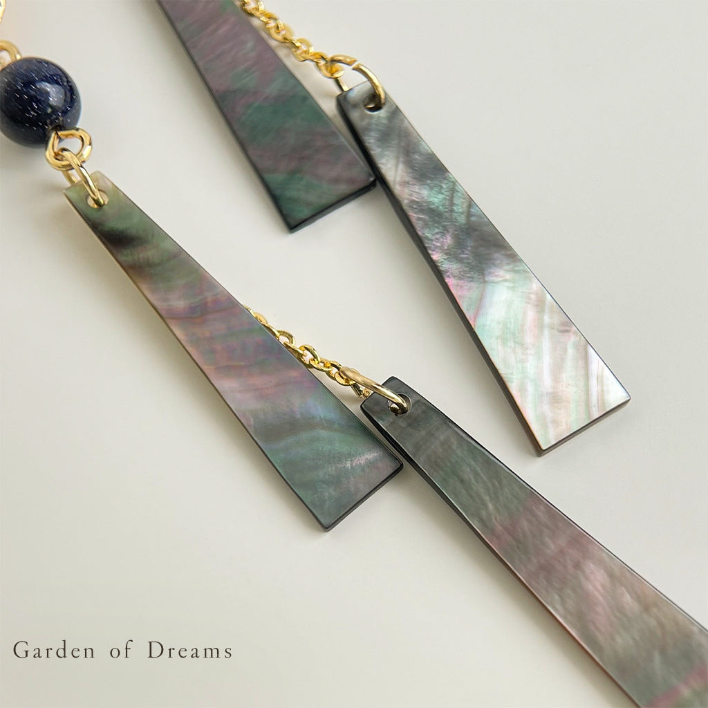 Pair of earrings with marbled design and gold accents on a light background