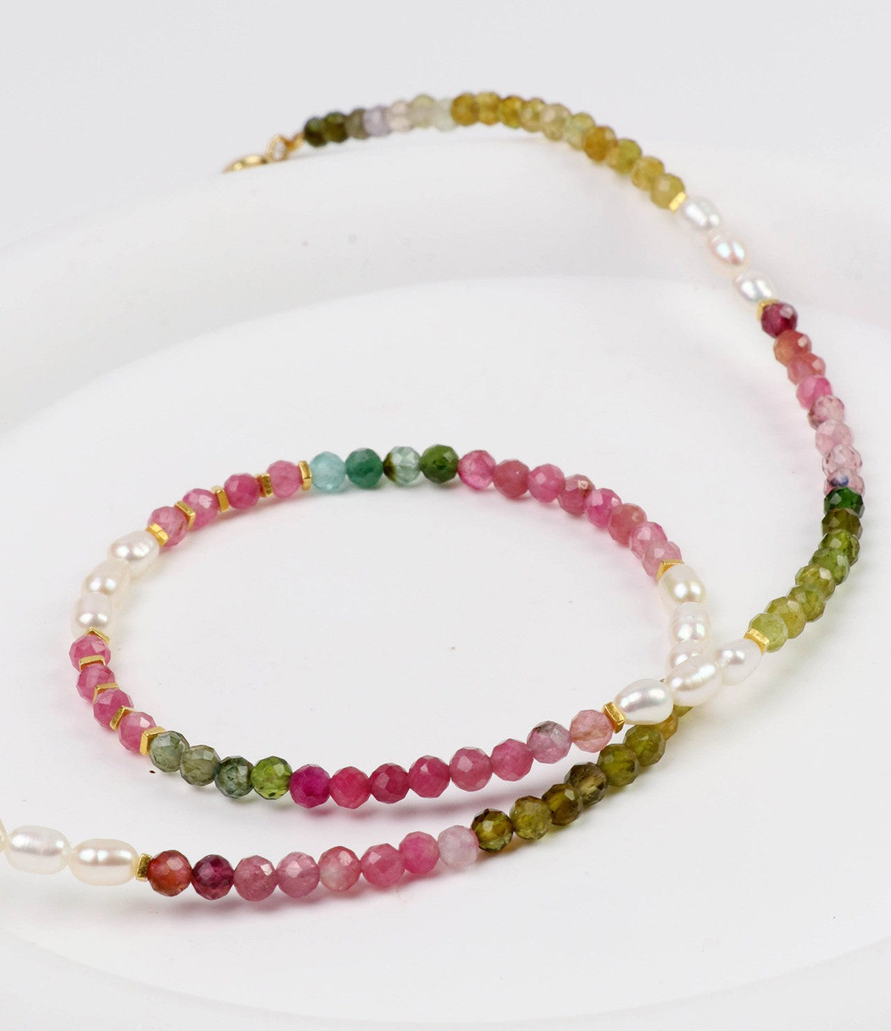 Set of three beaded necklaces with multicolored beads on a white background