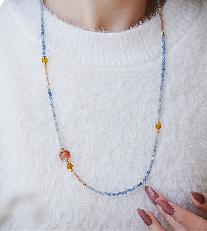 Necklace with multicolored beads on a white sweater