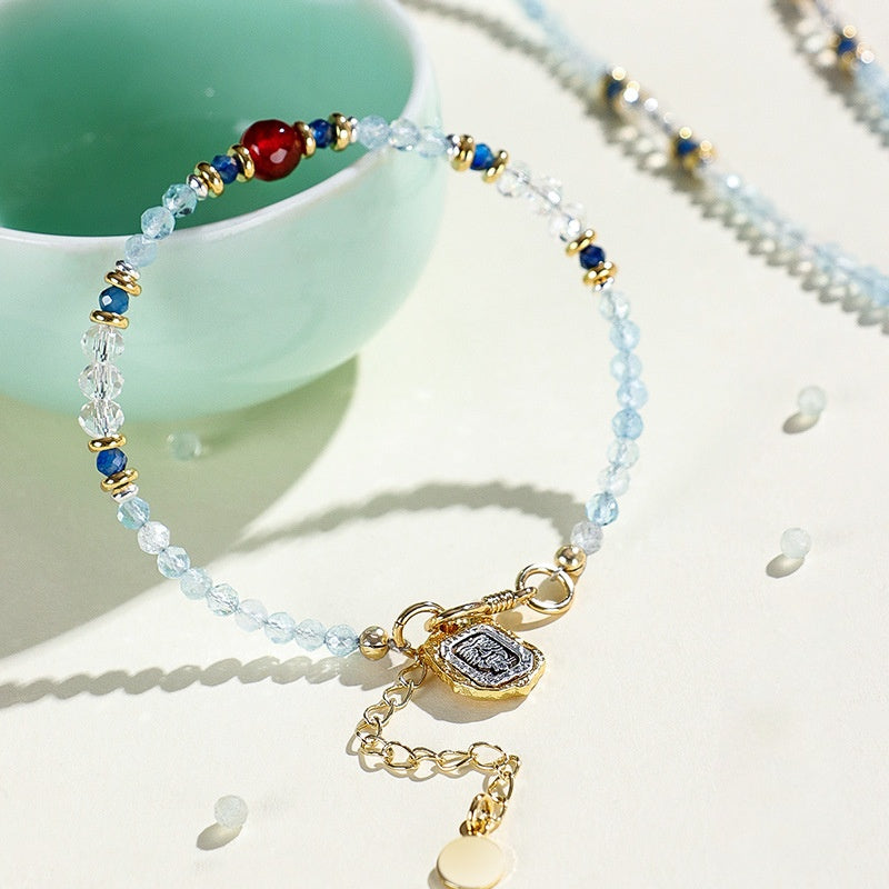 Beaded bracelet with gold charm on a light surface