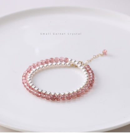 Two beaded bracelets, one pink and one silver, on a white surface.