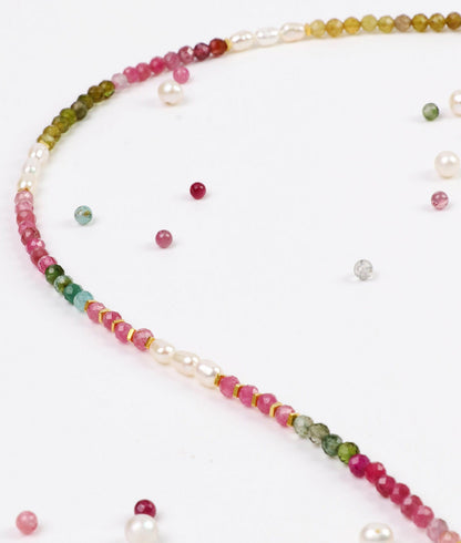Necklace with multicolored beads and pearls on a white background