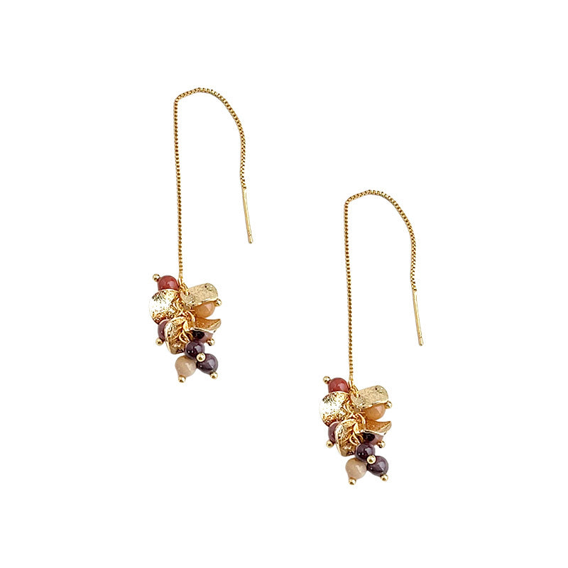 Gold earrings with multicolored beads on a white background