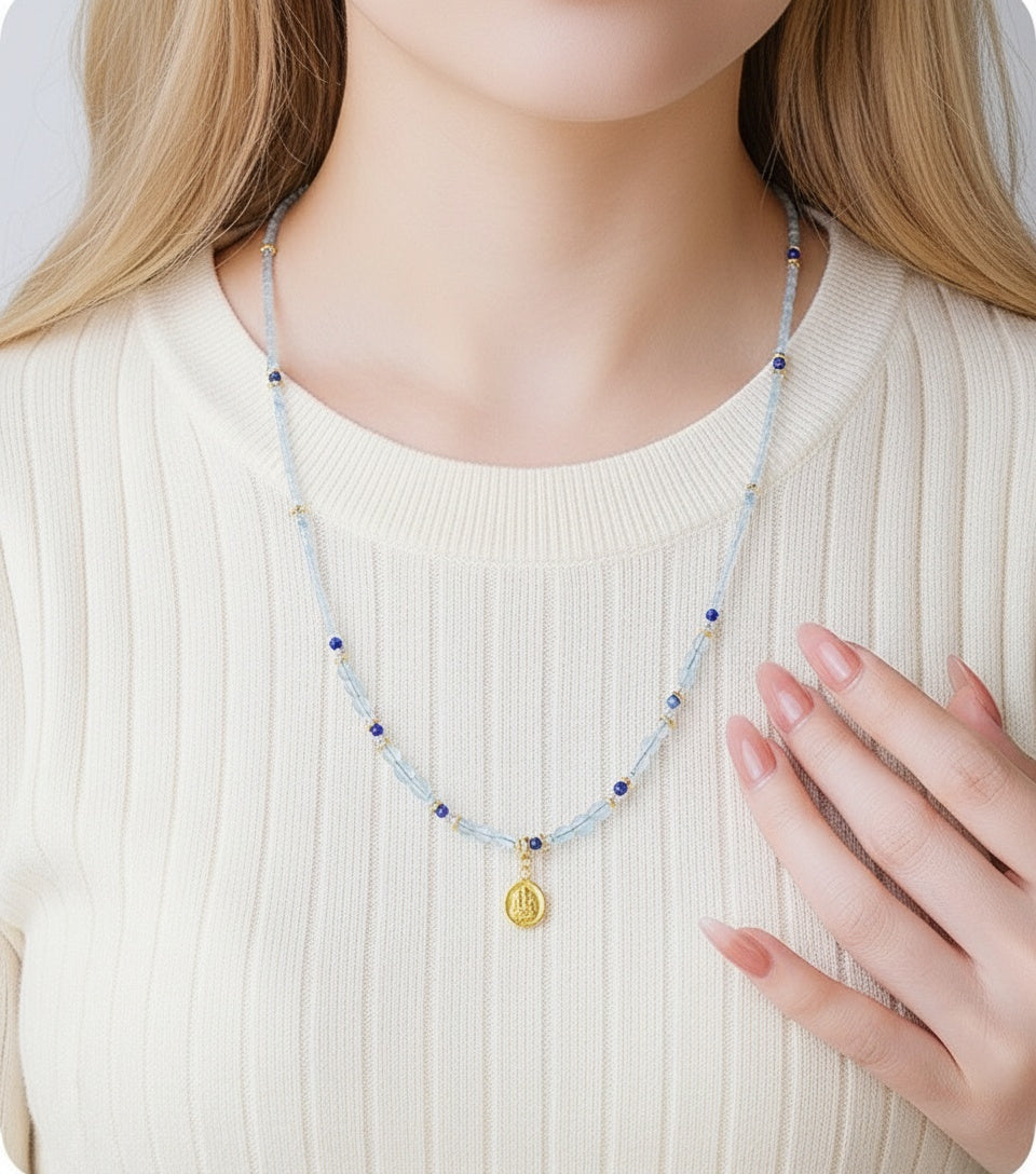 Necklace with a pendant worn by a person in a white sweater