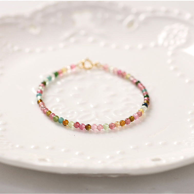 Multicolored beaded bracelet on a white textured plate