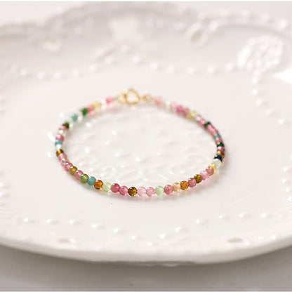 Multicolored beaded bracelet on a white textured plate