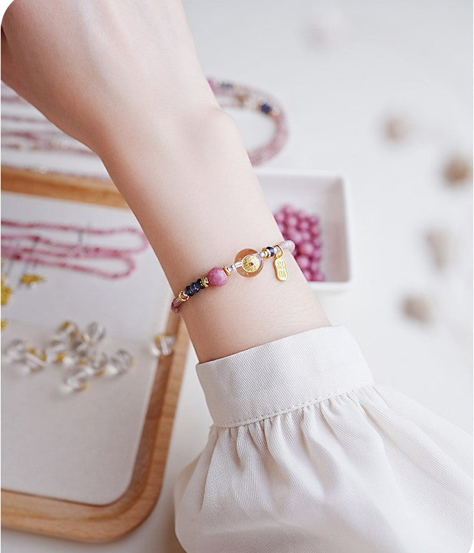 Close-up of a wrist wearing a colorful bracelet with a blurred background