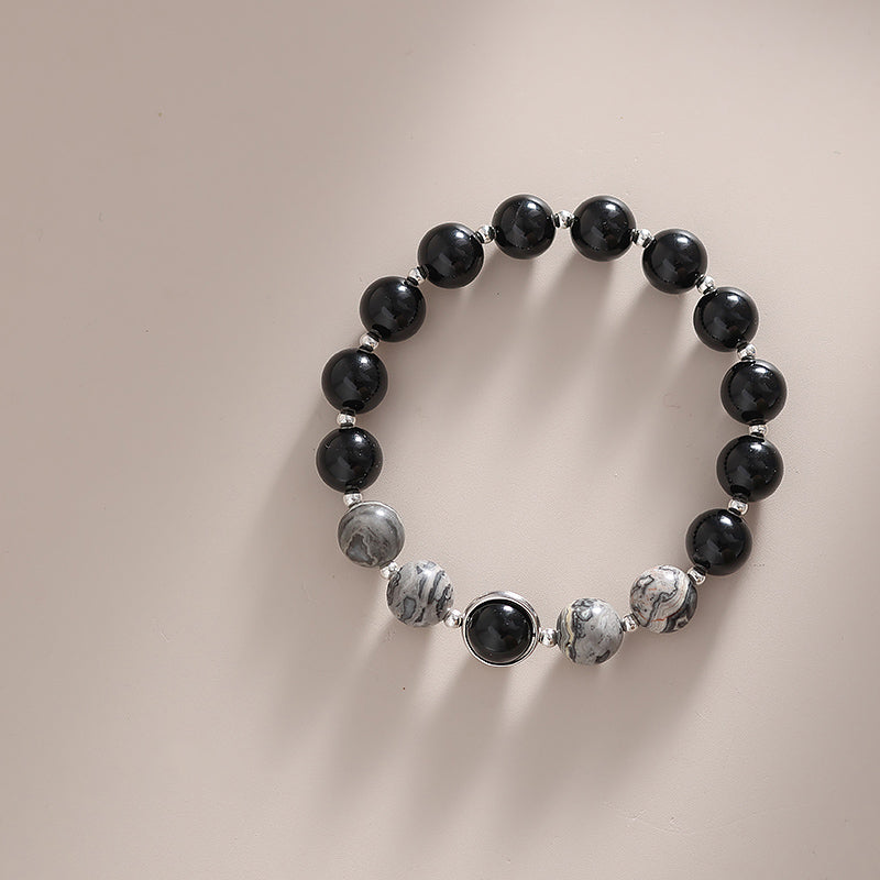 Black and gray beaded bracelet on a neutral background