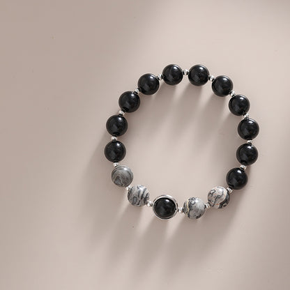 Black and gray beaded bracelet on a neutral background