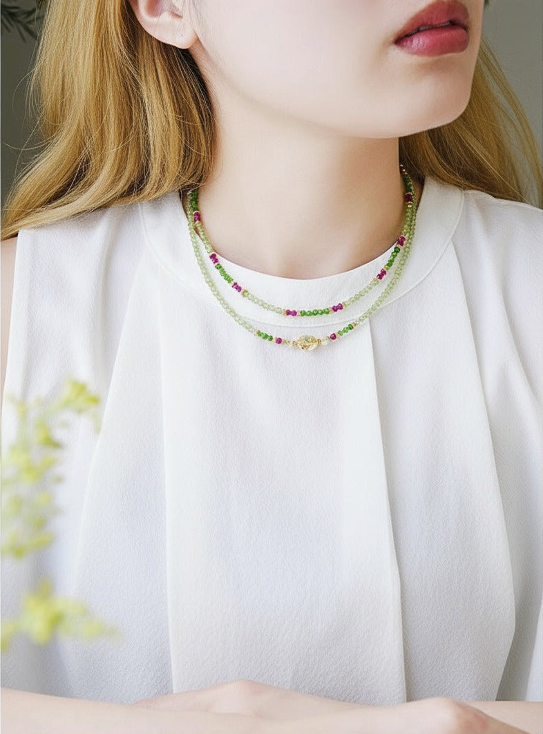 Close-up of a woman wearing a beaded necklace with a blurred background