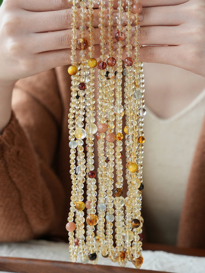 Multistrand beaded necklace held by a person with a blurred background