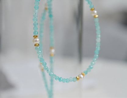Beaded necklace with turquoise beads and gold accents on a blurred background