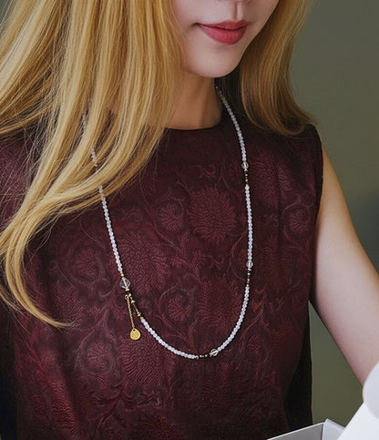 Woman wearing a pearl necklace with a blurred background