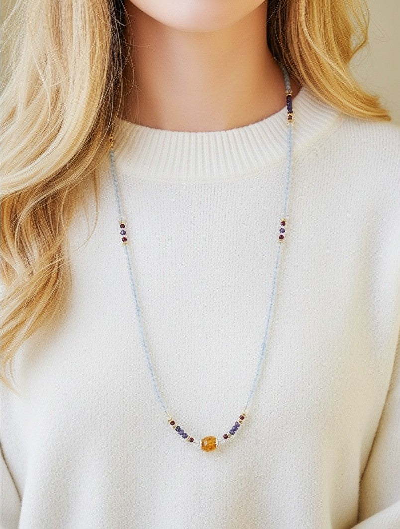 Necklace with colorful beads worn by a person in a white sweater