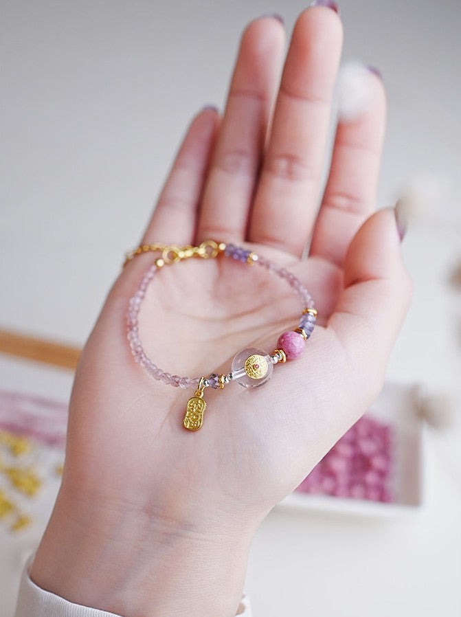 Hand wearing a colorful beaded bracelet with a blurred background