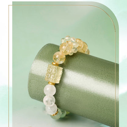 Bracelet with gold and white beads on a green background
