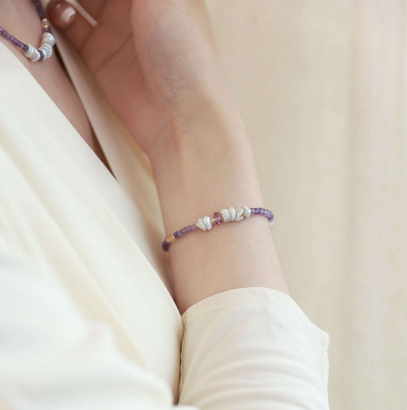 Purple beaded bracelet on a wrist with a blurred background