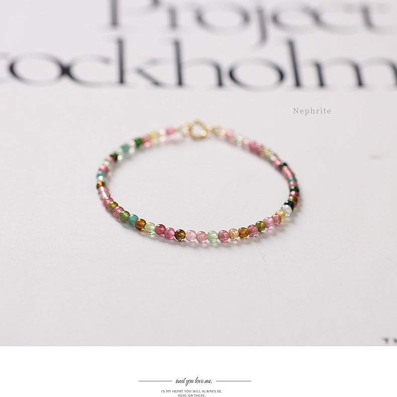 Multicolored beaded bracelet on a white surface with 'Nephrite' text.