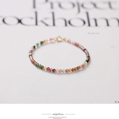 Multicolored beaded bracelet on a white surface with 'Nephrite' text.