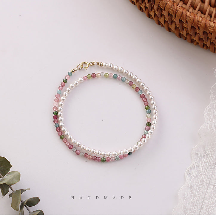 Handmade bracelet with multicolored beads on a white surface.