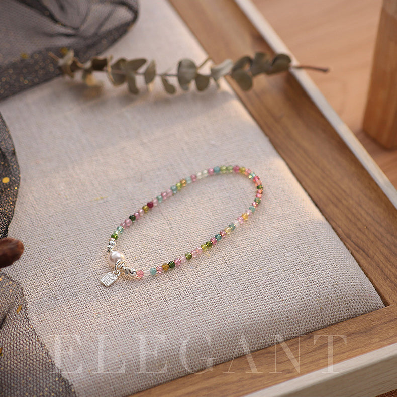 Multicolored beaded bracelet on a textured surface with a neutral background.