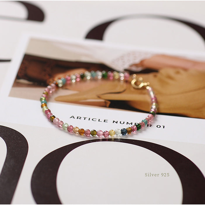Multicolored beaded bracelet on a magazine with 'Silver 925' text