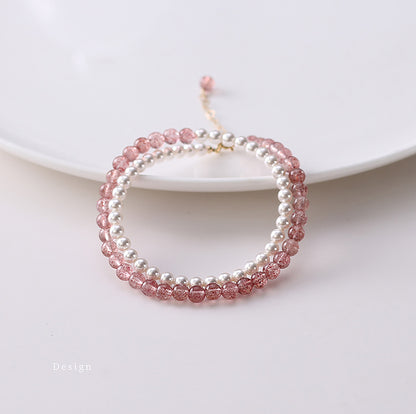 Two beaded bracelets, one pink and one white, on a white plate.