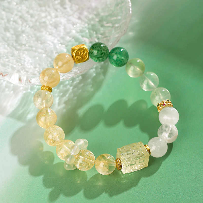 Beaded bracelet with yellow, green, and white stones on a light green background