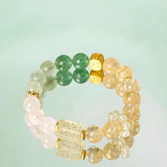 Multicolored beaded bracelet with gold accents on a light green background