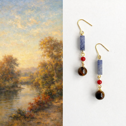 Pair of earrings with beads against a landscape painting background