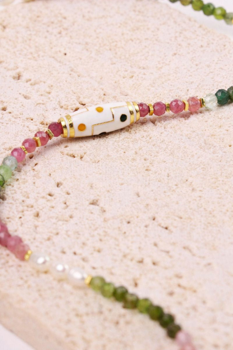 Beaded necklace with multicolored beads on a sandy background