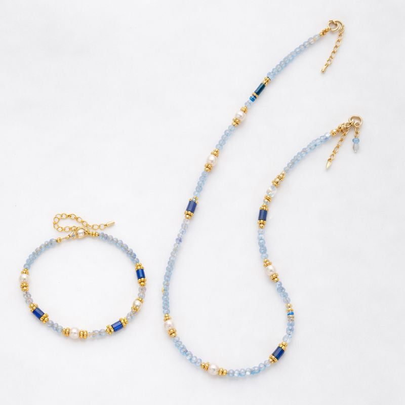 Beaded necklace and bracelet set with blue and gold beads on a white background