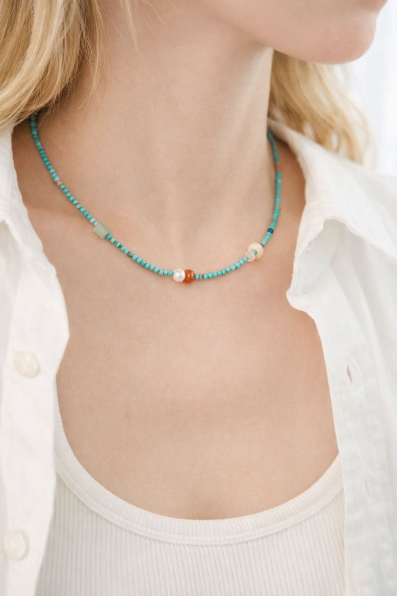 Necklace with turquoise beads and a white shirt worn by a person