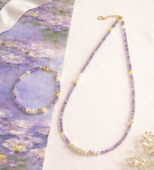 Necklace and bracelet set on a surface with a floral background