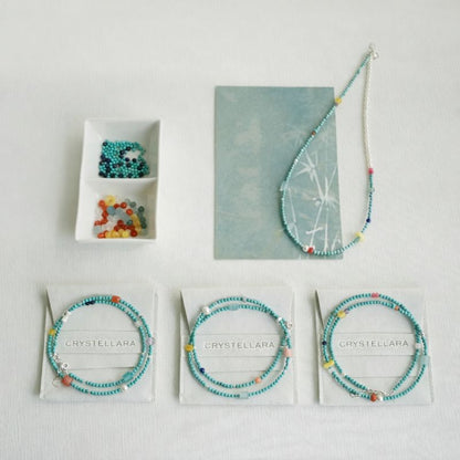 Jewelry set with beaded bracelets and a necklace on a light gray background